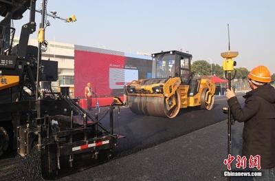 無人駕駛瀝青道路攤鋪壓實(shí)設(shè)備在滬上路施工